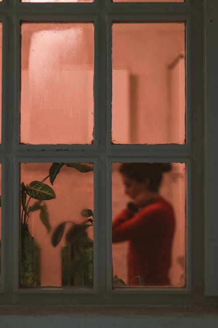 Person reflected in window with plants